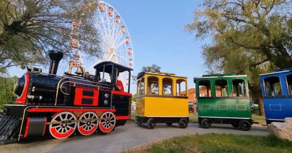 Happy Train kerekes, családi kisvonat a Móló sétányon, háttérben az óriáskerékkel.